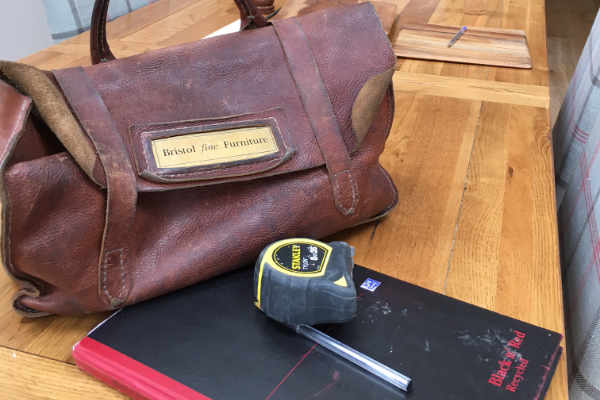 Notebook tape measure and toolbag on kitchen table